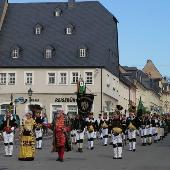 Bergmannsumzug von verkleideten Menschen durch die Straßen von Lingens Partnerstadt Marienberg 