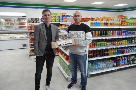 Jonas Berger vom Citymanagement (li.) gratuliert Yunis Ahmed, dem Inhaber des neu eröffneten Lebensmittelmarktes Yamix.