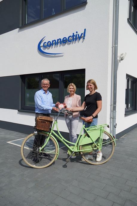 Geschäftsführer Hermann Silies (links) und Mitarbeiterin Anna Bollmann (rechts) nehmen die Auszeichnung zum „fahrradfreundlichen Betrieb“ von Miriam Focks der Wirtschaftsförderung Lingen (Ems) entgegen.