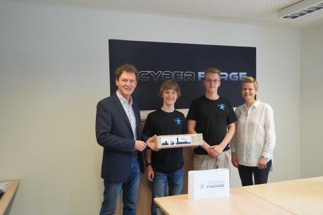 Oberbürgermeister Dieter Krone und Sandra Prekel von der Wirtschaftsförderung zu Besuch beim Cyberforge Team v.l. Fabian Saatkamp und Noah Gels.