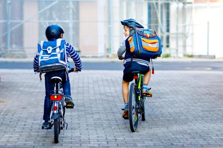 Schulweg mit zwei Schulkindern auf dem Fahrrad